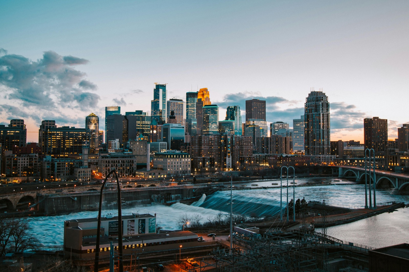 Minneapolis skyline at twilight, with the Stone Arch Bridge area in the foreground